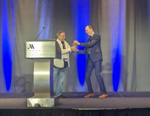 IUG Chair Wes Osborn awards Daniel Messer the IUG Beacon Award